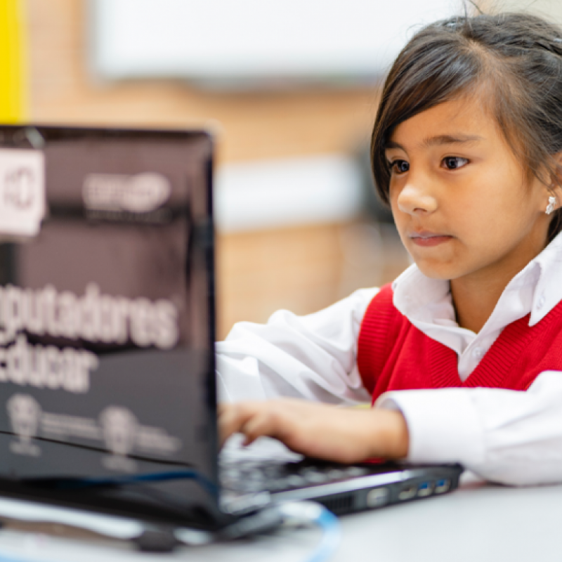 Niña estudiando con computador 