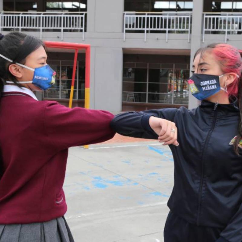 niñas saludando con el codo en el colegio Enrique Olaya Herrera 