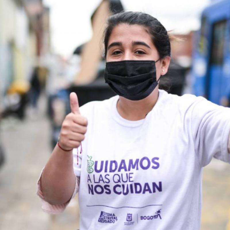 mujer saludando con camiseta del sistema de cuidado 